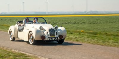 a white car driving down a country road