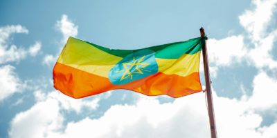 Ethiopian national flag waving under a clear blue sky, symbolizing freedom and hope.