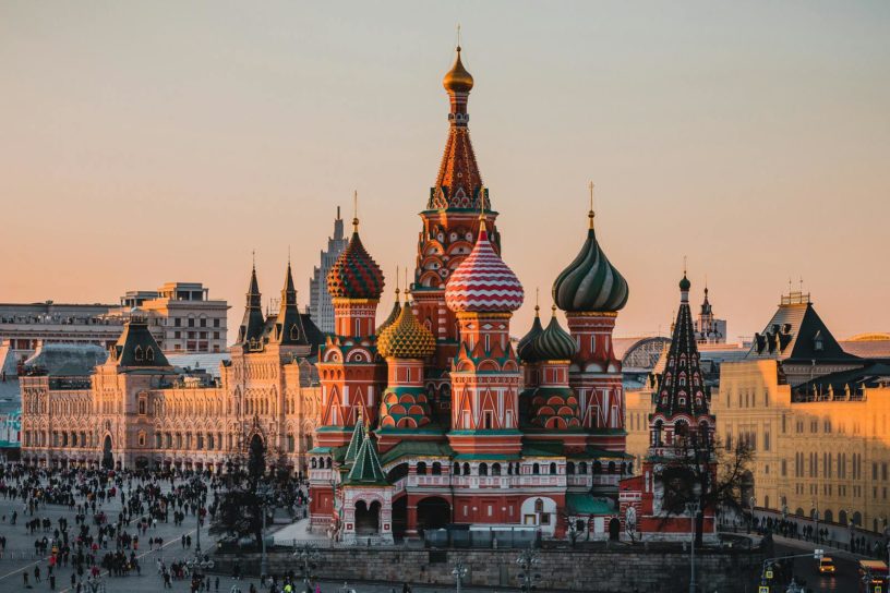 Stunning view of St. Basil's Cathedral in Moscow during sunset with a bustling crowd.