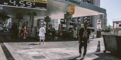 Stylish youth at a Petrobras gas station in a bustling urban setting.